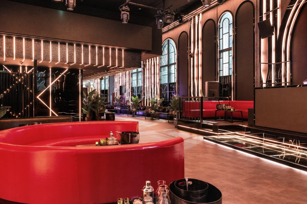 Lounge interior with red leather seating, arched windows and LED lighting by PC Interiors
